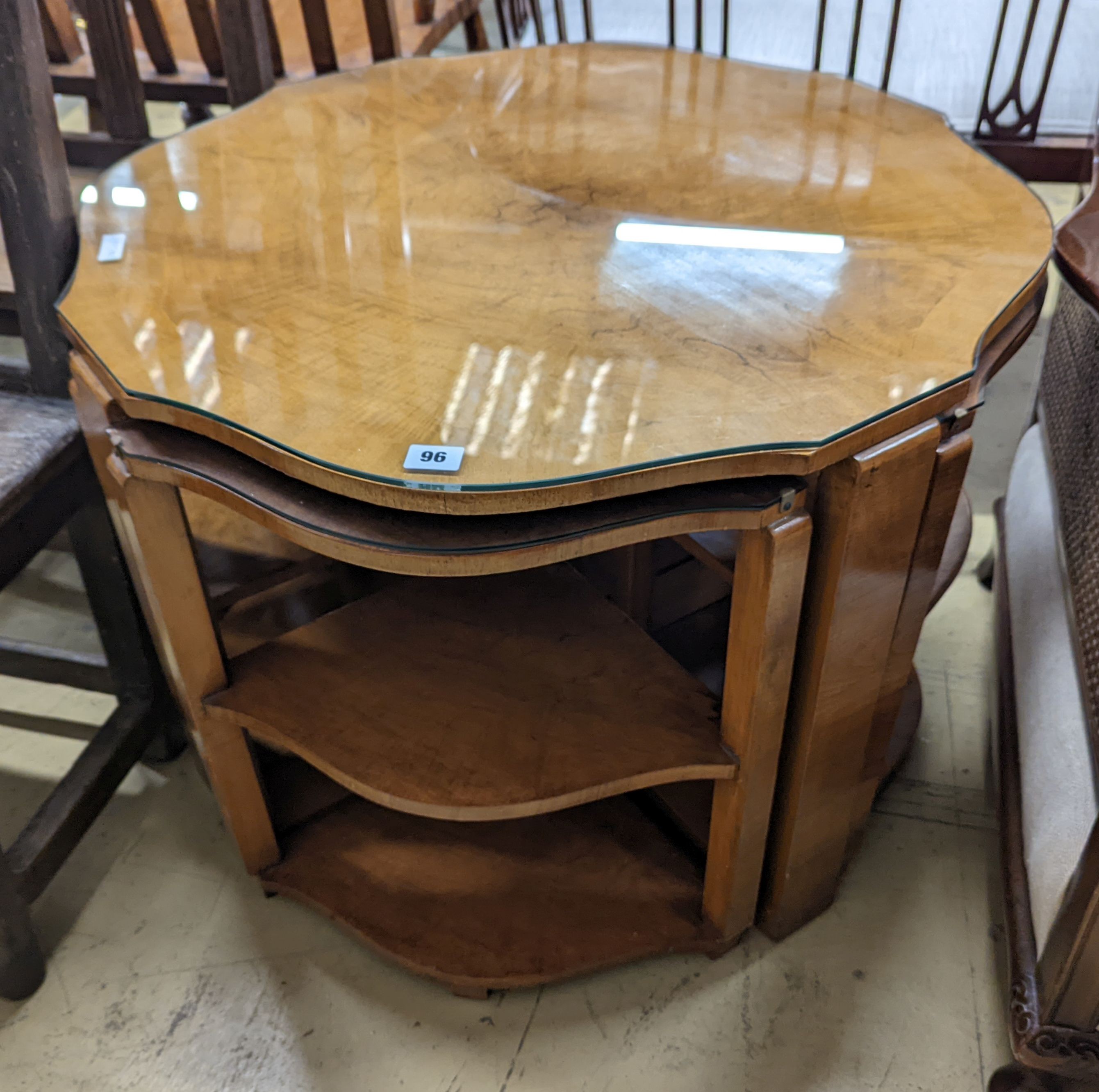 An Art Deco style cross banded walnut nest of tables of circular serpentine form, diameter 72cm, height 54cm